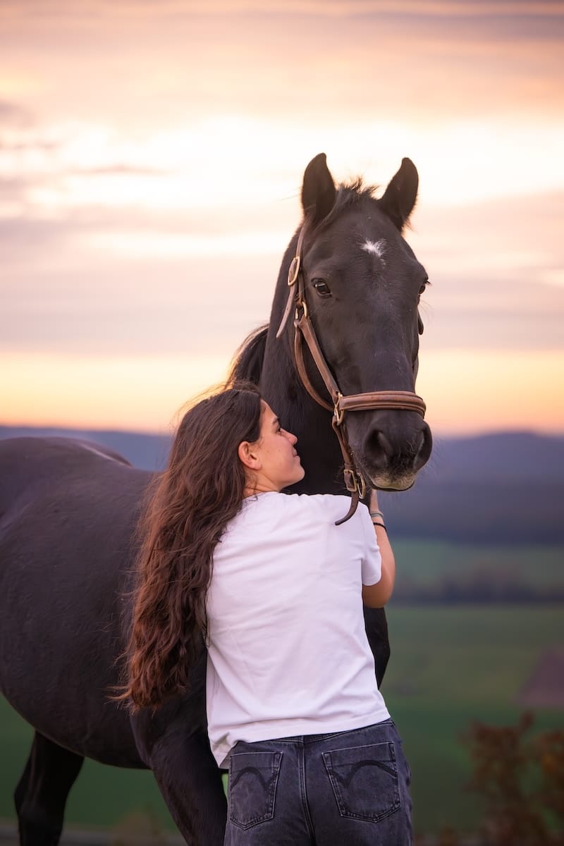 Moment de détente entre une jeune femme et un cheval